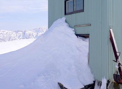 雪で埋った小屋の入り口の写真